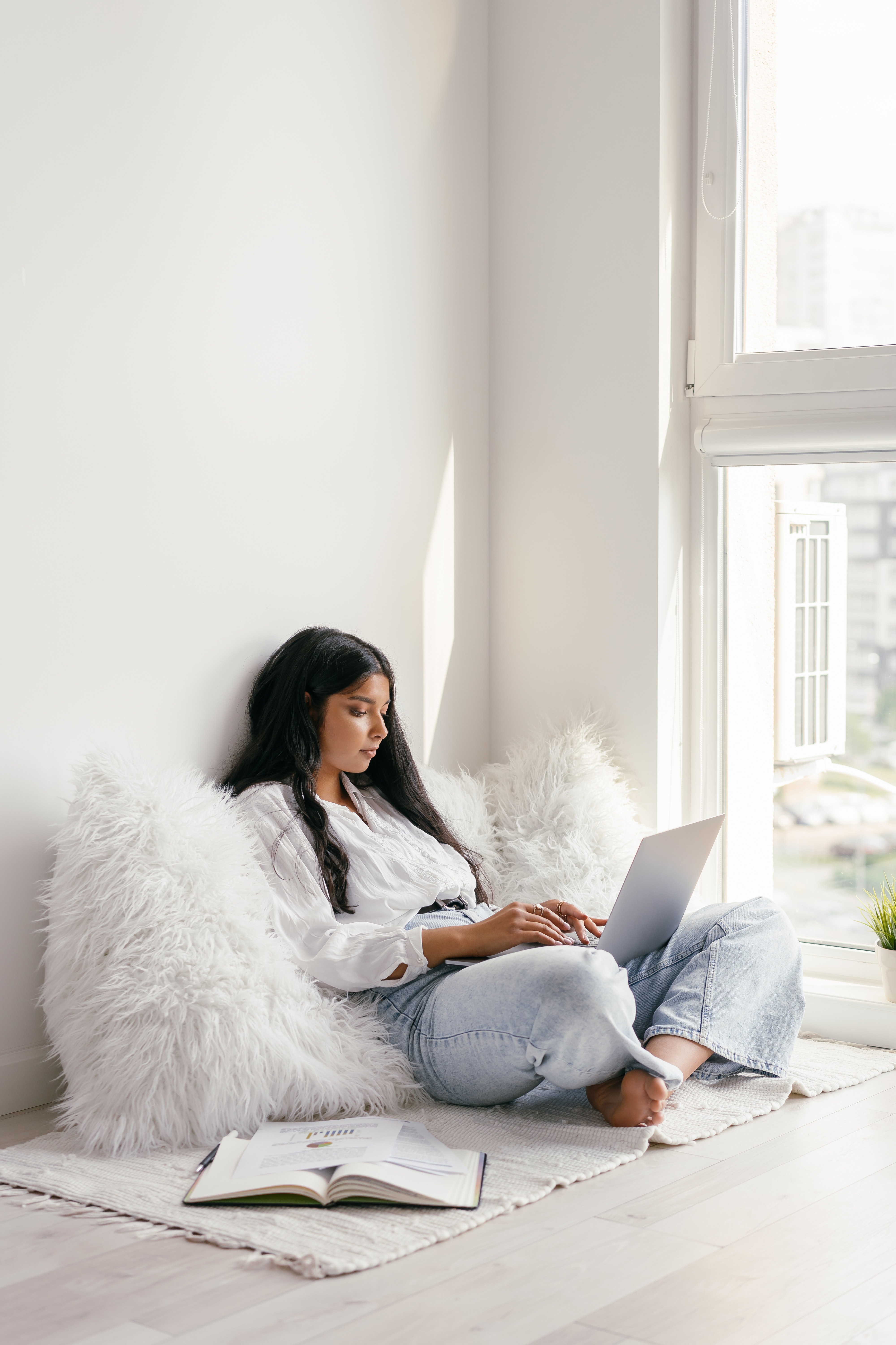 lady sitting on pillow with her laptop